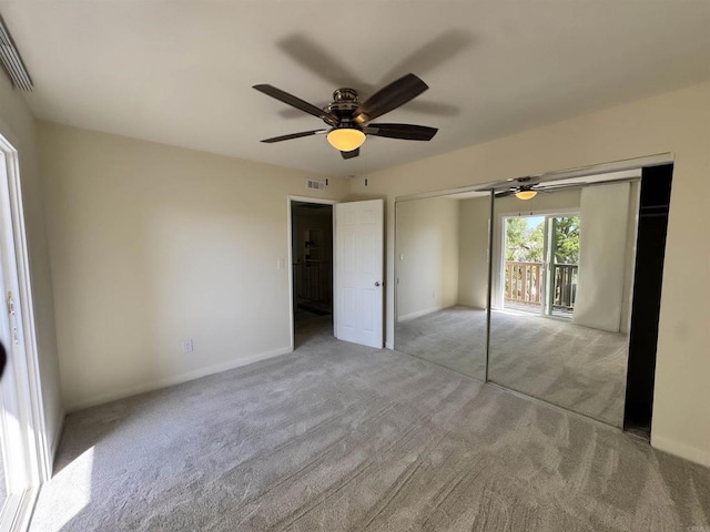 unfurnished bedroom featuring ceiling fan, light colored carpet, and a closet