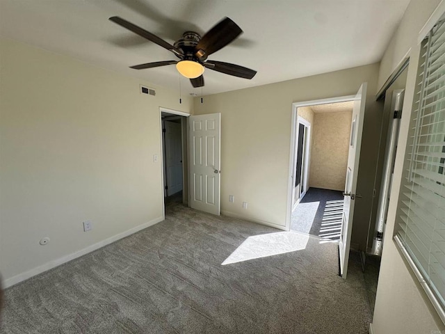 unfurnished bedroom featuring dark colored carpet and ceiling fan