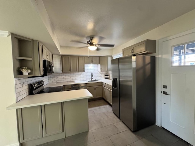 kitchen featuring sink, kitchen peninsula, decorative backsplash, light tile patterned floors, and appliances with stainless steel finishes