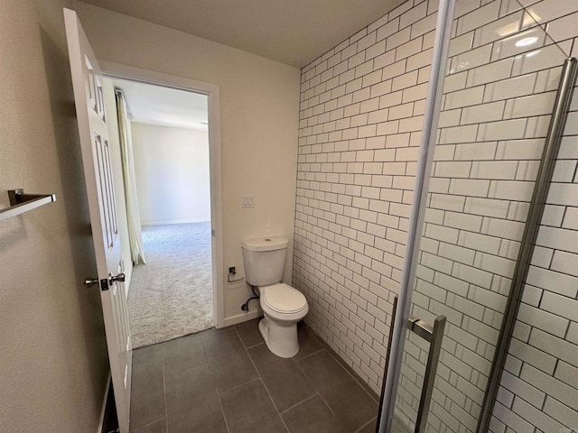 bathroom with tile patterned flooring, an enclosed shower, and toilet