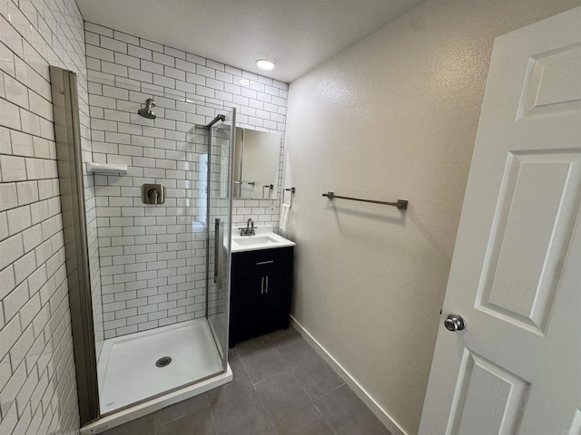 bathroom with tile patterned flooring, vanity, and walk in shower