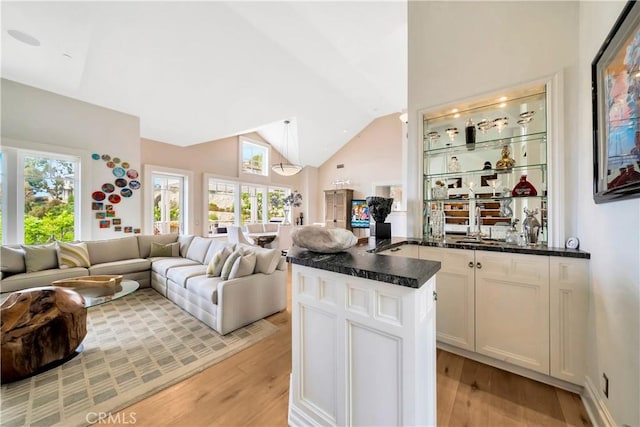 kitchen with pendant lighting, a center island, sink, light hardwood / wood-style flooring, and white cabinetry