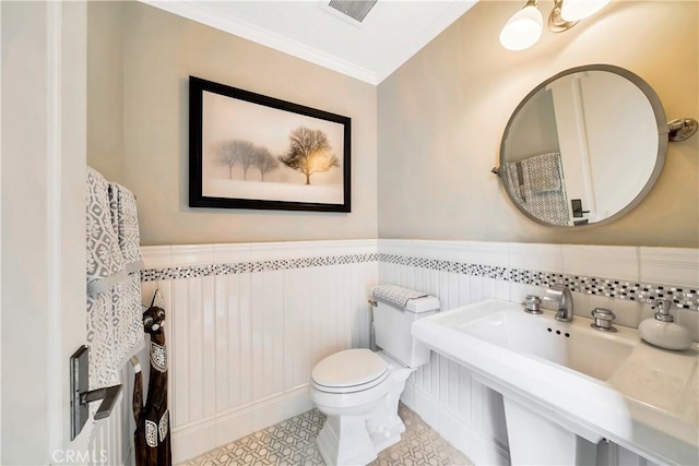 bathroom with crown molding, sink, and toilet