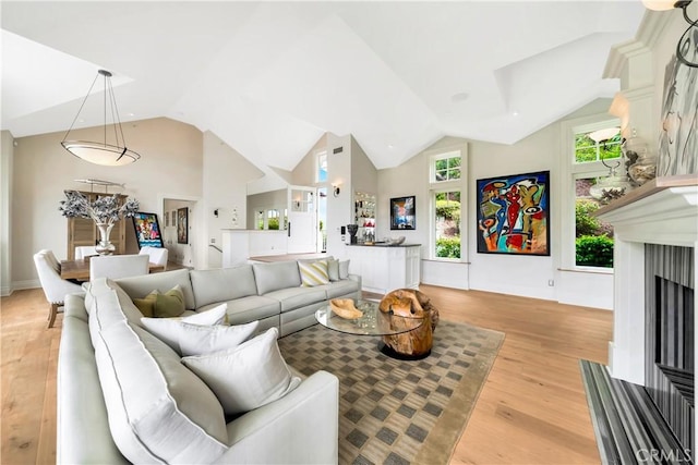 living room with light hardwood / wood-style floors and lofted ceiling