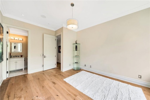 unfurnished bedroom with connected bathroom, crown molding, sink, and light wood-type flooring