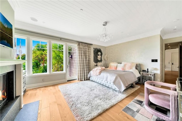 bedroom featuring wooden ceiling, light hardwood / wood-style flooring, ornamental molding, and an inviting chandelier