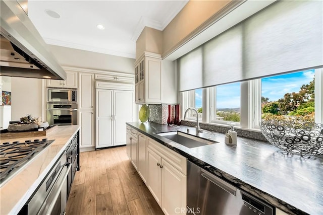 kitchen featuring sink, decorative backsplash, light wood-type flooring, white cabinetry, and stainless steel appliances