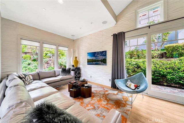 living room with light hardwood / wood-style floors, vaulted ceiling, and a wealth of natural light