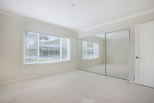 unfurnished bedroom with light carpet, a closet, and ornamental molding