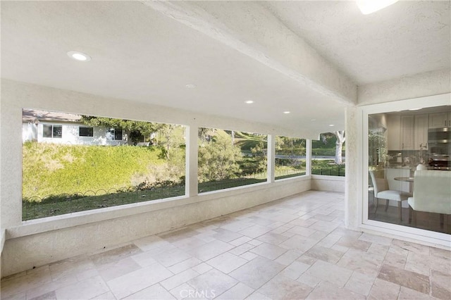 unfurnished sunroom with ceiling fan