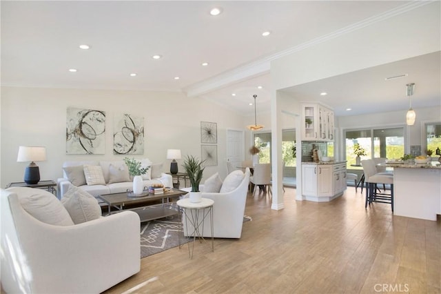 living room featuring vaulted ceiling with beams, light hardwood / wood-style flooring, and ornamental molding