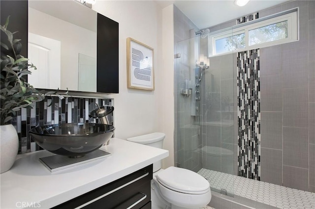 bathroom with decorative backsplash, toilet, walk in shower, and vanity