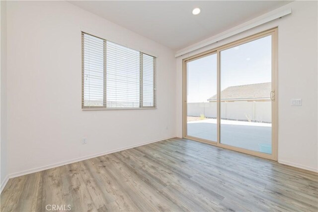 unfurnished room featuring a healthy amount of sunlight and light hardwood / wood-style flooring