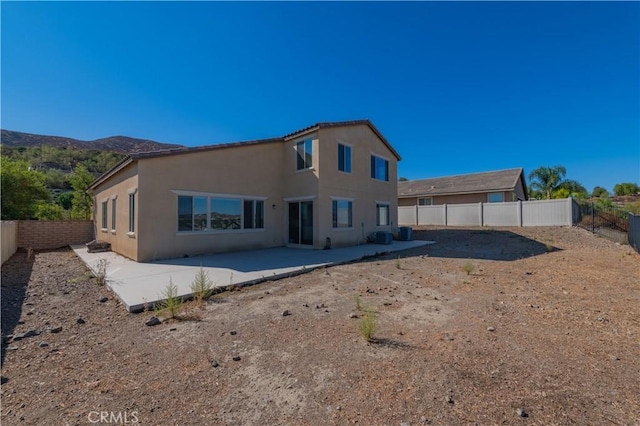 rear view of house with a mountain view and a patio area