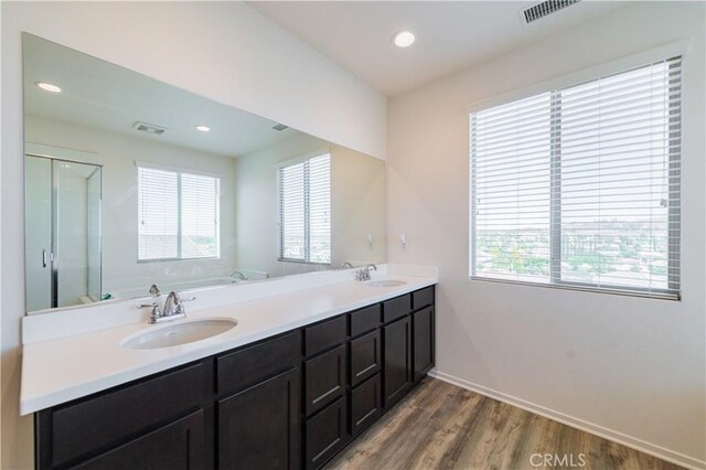 bathroom with wood-type flooring, vanity, a wealth of natural light, and independent shower and bath