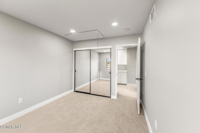 unfurnished bedroom with light carpet and a closet