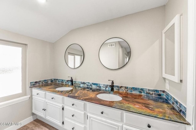 bathroom with vanity, plenty of natural light, and lofted ceiling