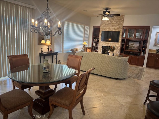 dining room featuring a fireplace, built in features, and ceiling fan with notable chandelier