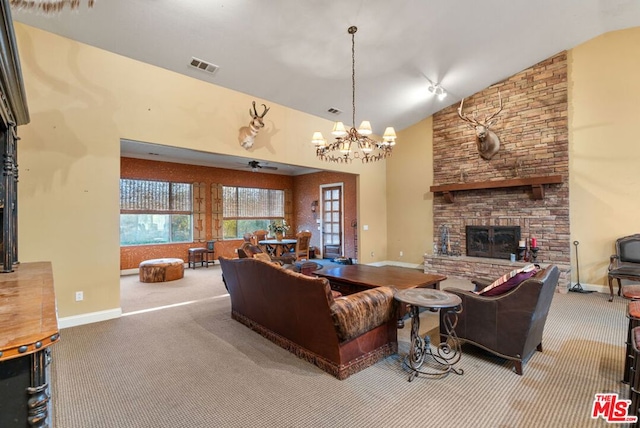 carpeted living room featuring ceiling fan with notable chandelier, a stone fireplace, and high vaulted ceiling