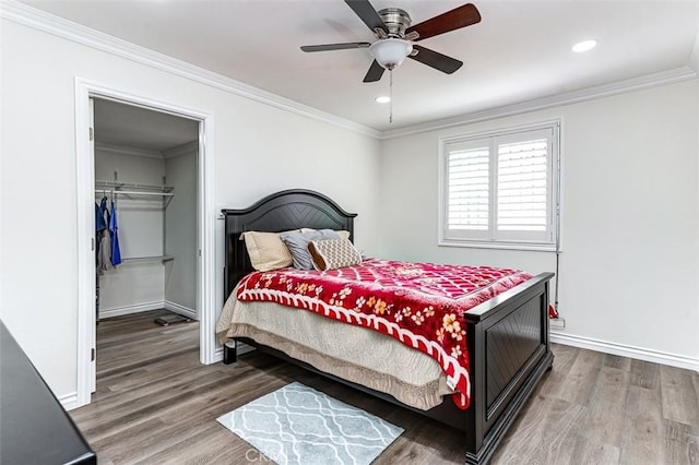 bedroom with hardwood / wood-style floors, ceiling fan, crown molding, and a closet