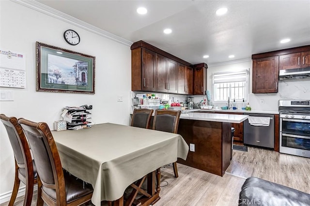 kitchen with light wood-type flooring, a breakfast bar, dark brown cabinetry, stainless steel appliances, and crown molding