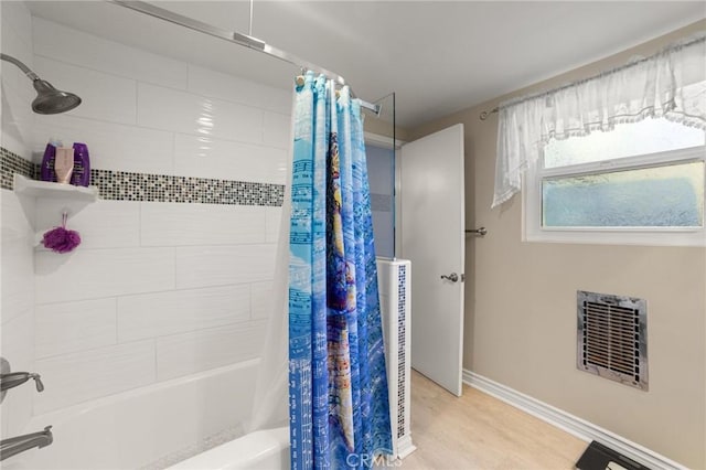 bathroom with hardwood / wood-style floors, shower / bath combo with shower curtain, and heating unit