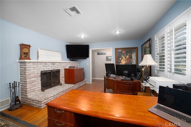 office featuring a fireplace and light hardwood / wood-style floors