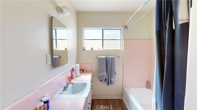 bathroom featuring wood-type flooring, vanity, and shower / tub combo