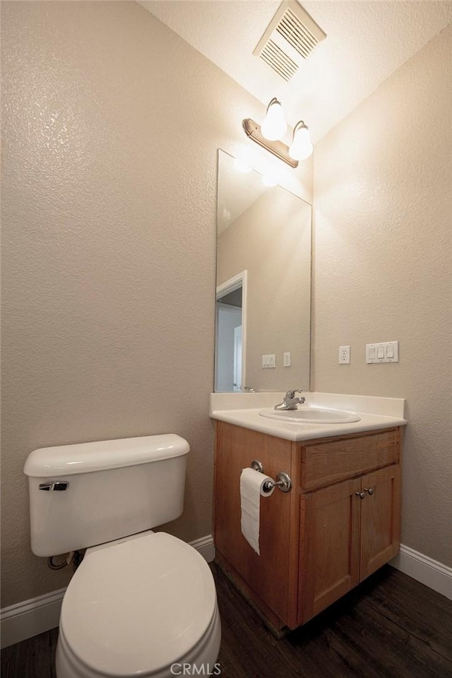 bathroom with wood-type flooring, vanity, and toilet