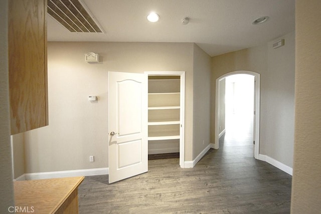 corridor with dark hardwood / wood-style flooring