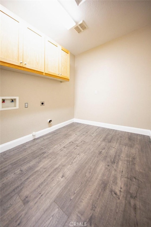 washroom featuring hookup for an electric dryer, cabinets, dark wood-type flooring, and hookup for a washing machine