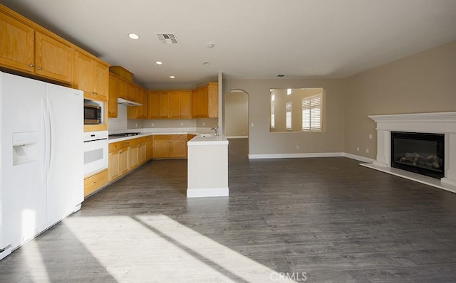 kitchen featuring sink, dark wood-type flooring, white appliances, and light brown cabinets