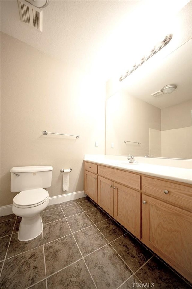 bathroom featuring tile patterned flooring, vanity, and toilet