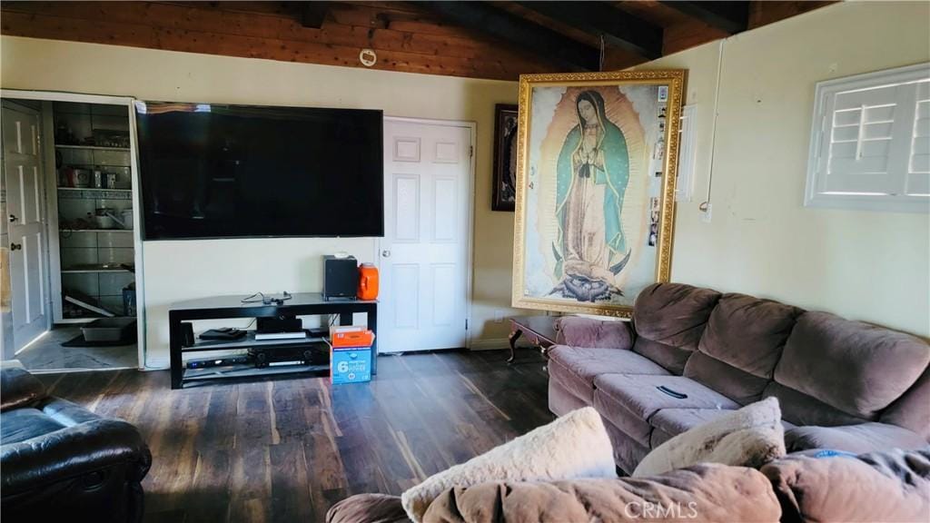 living room featuring vaulted ceiling with beams and dark hardwood / wood-style floors