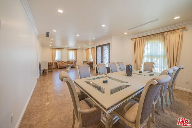 tiled dining room featuring crown molding