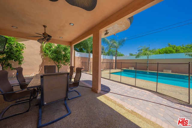 view of patio / terrace with ceiling fan and a fenced in pool