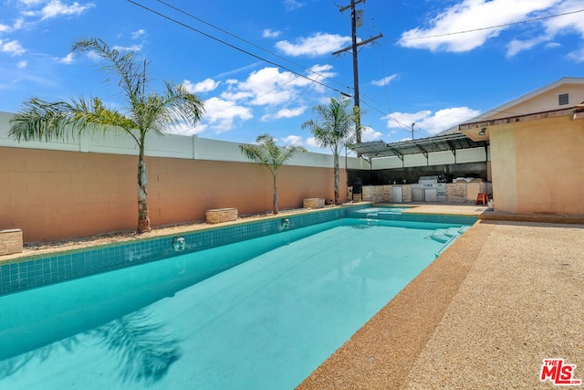 view of pool featuring exterior kitchen