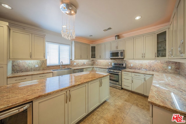 kitchen featuring decorative light fixtures, sink, light stone counters, and stainless steel appliances