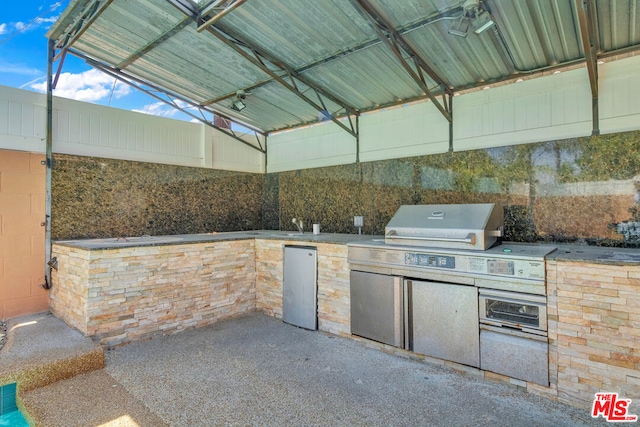 view of patio featuring exterior kitchen and grilling area