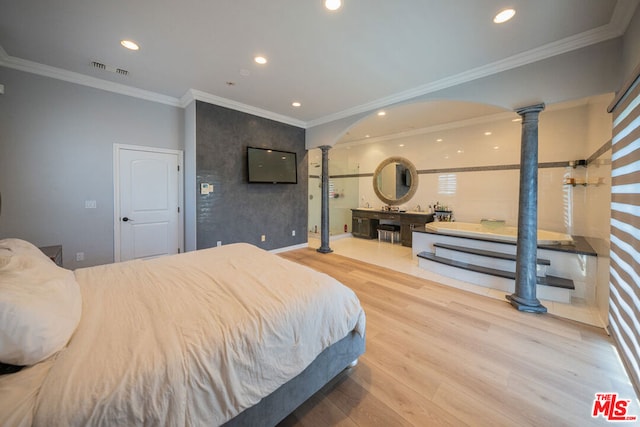 bedroom featuring ornate columns, ornamental molding, and hardwood / wood-style flooring