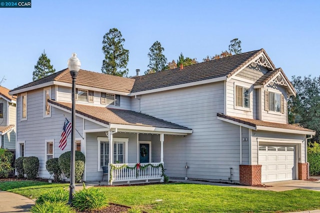 view of front of home with a porch, a garage, and a front lawn