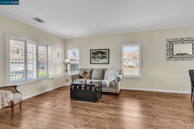 living room featuring crown molding, plenty of natural light, and hardwood / wood-style floors