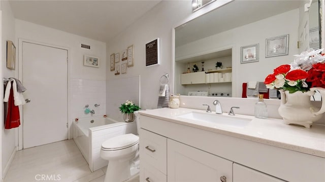 bathroom with tile patterned flooring, vanity, toilet, and a tub to relax in