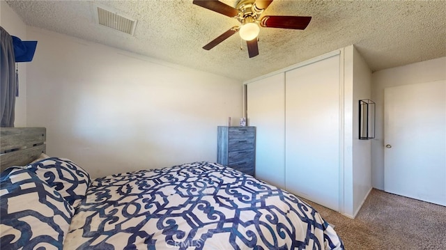 unfurnished bedroom with carpet, a textured ceiling, a closet, and ceiling fan