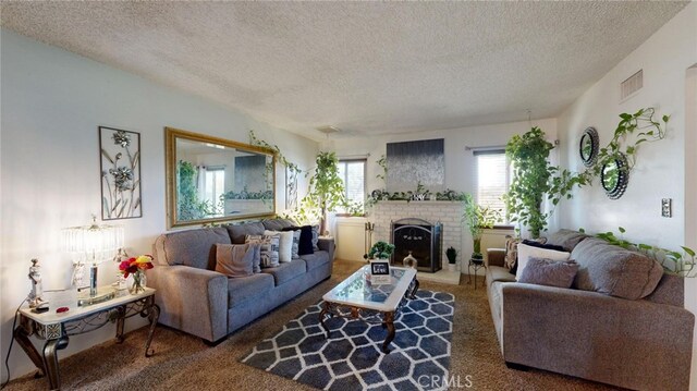 living room with carpet flooring, a textured ceiling, and a brick fireplace