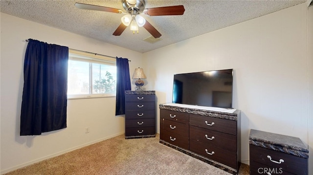 carpeted bedroom with ceiling fan and a textured ceiling