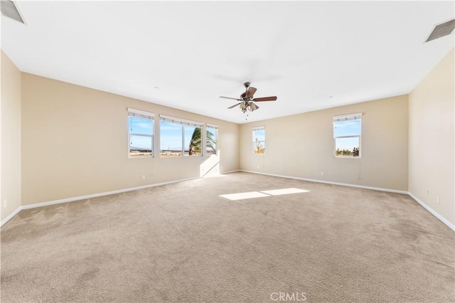 carpeted empty room with plenty of natural light and ceiling fan