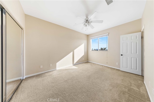 unfurnished bedroom with ceiling fan, a closet, and light carpet