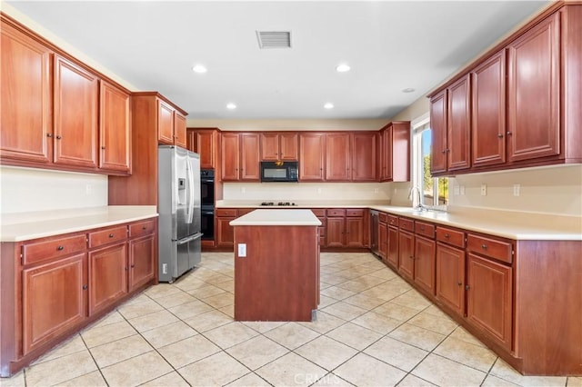 kitchen with a center island, light tile patterned flooring, sink, and appliances with stainless steel finishes