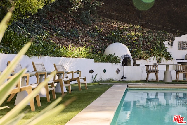 view of swimming pool featuring a yard